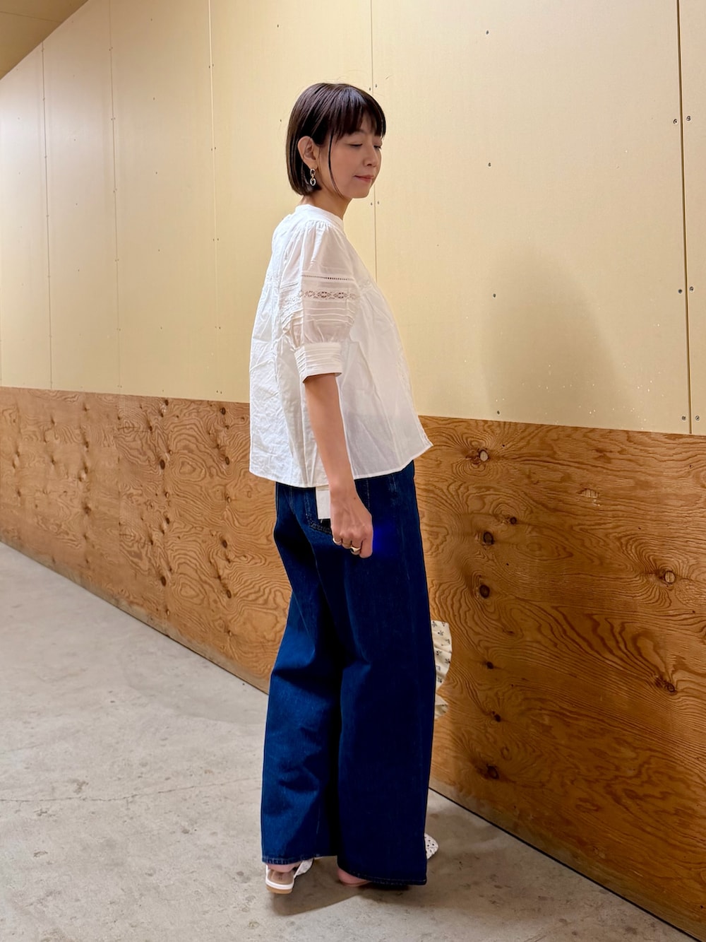 ブルー系のデニムパンツ、ホワイト系のトートバッグ、ホワイト系のサンダルを着用したレディースの夏コーディネートの7枚目の写真