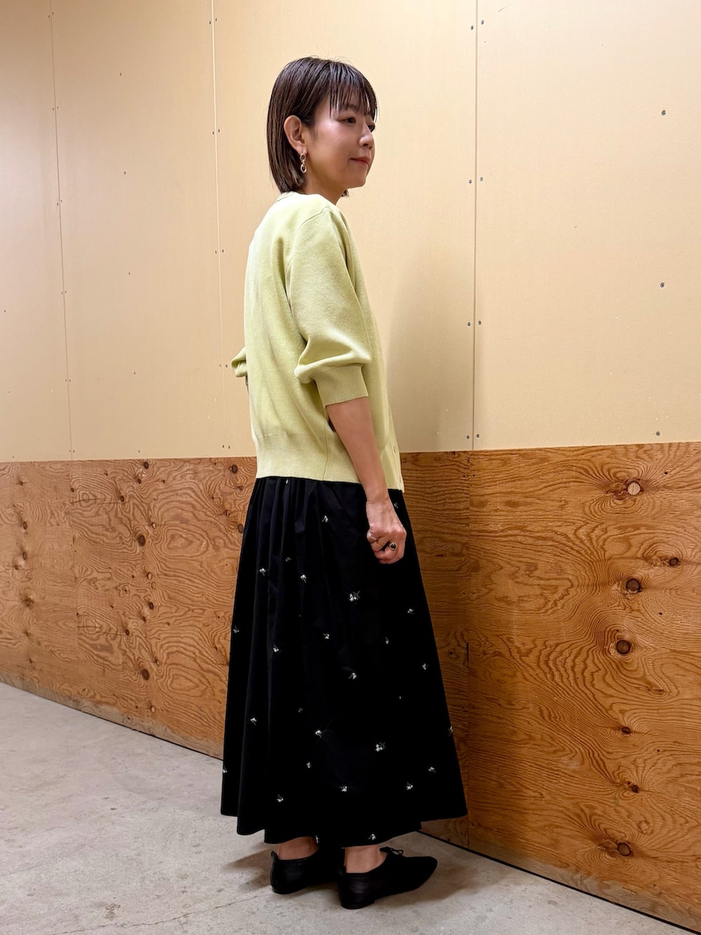 イエロー系のカーディガン/ボレロ、ブラック系のスカート、ホワイト系のTシャツ/カットソーを着用したレディースの春コーディネートの4枚目の写真