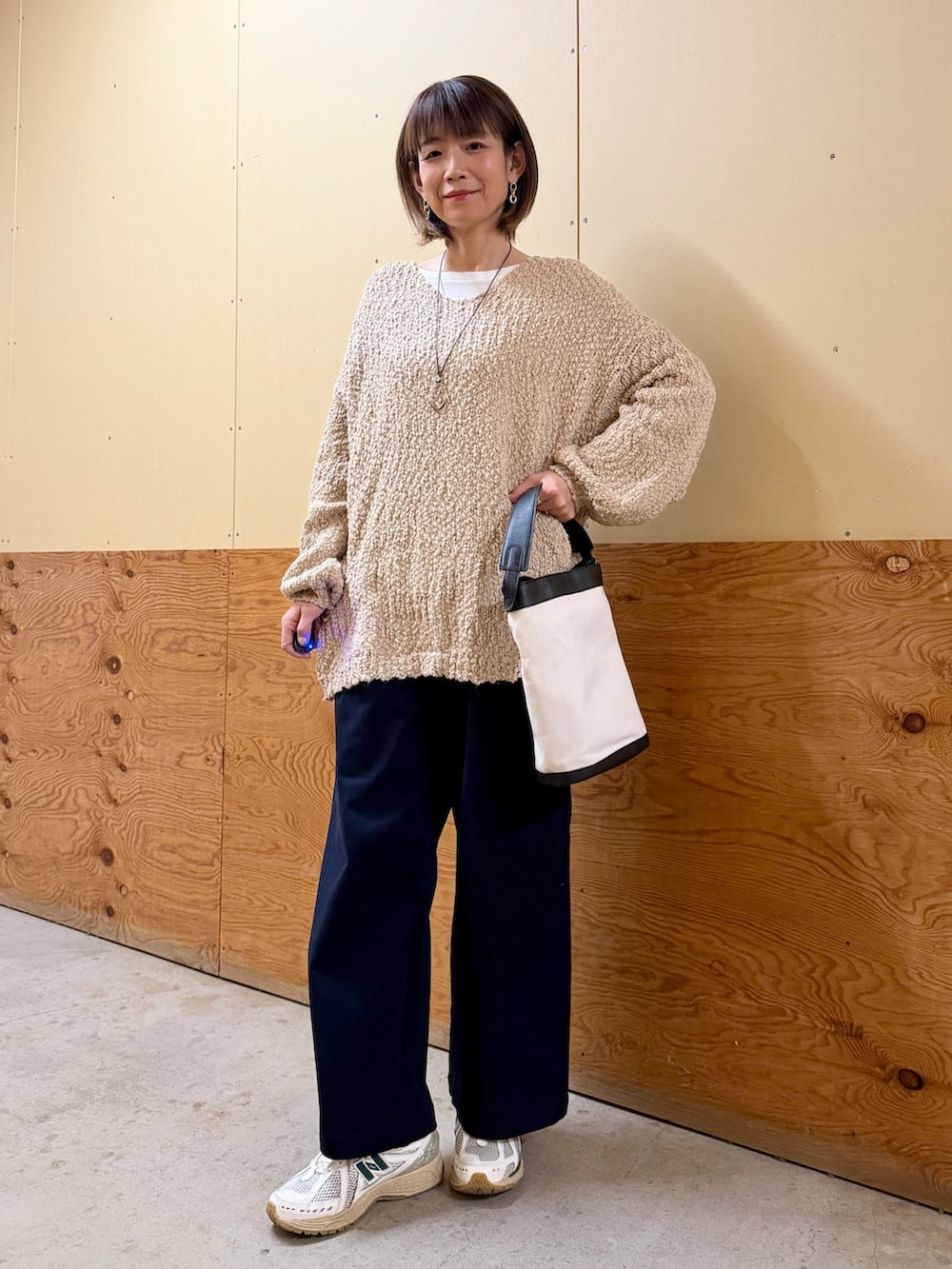 ベージュ系のニット/セーター、ブルー系のその他パンツ、ブラック系のショルダーバッグを着用したレディースの春コーディネートの3枚目の写真