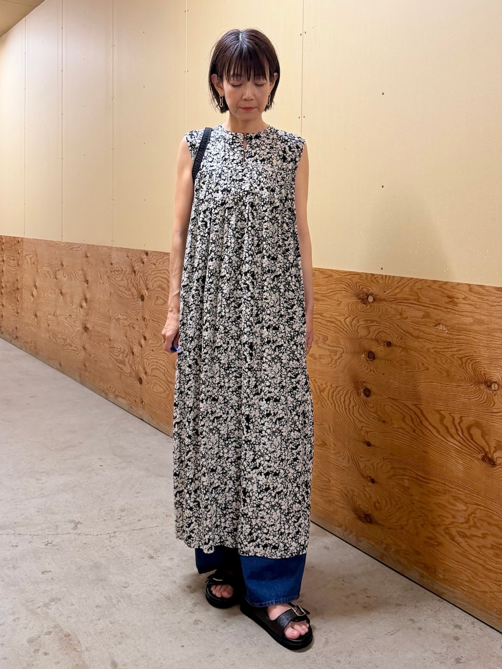 ブラック系のワンピース、ブルー系のデニムパンツ、ブラック系のサンダルを着用したレディースの夏コーディネートの7枚目の写真