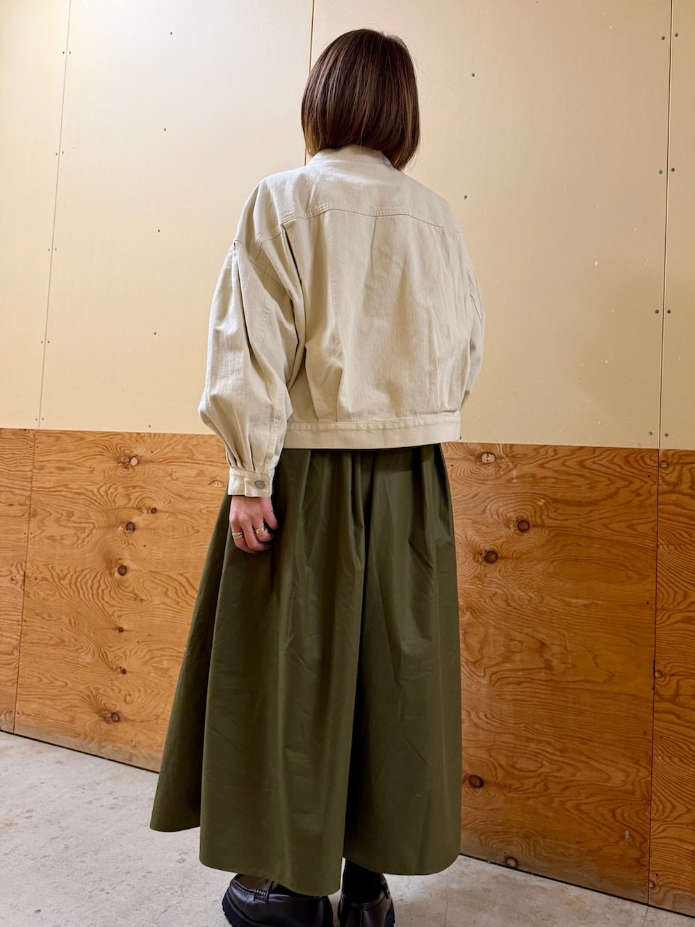 ホワイト系のブルゾン、ブラック系のシャツ/ブラウス、グリーン系のスカートを着用したレディースの冬コーディネートの5枚目の写真