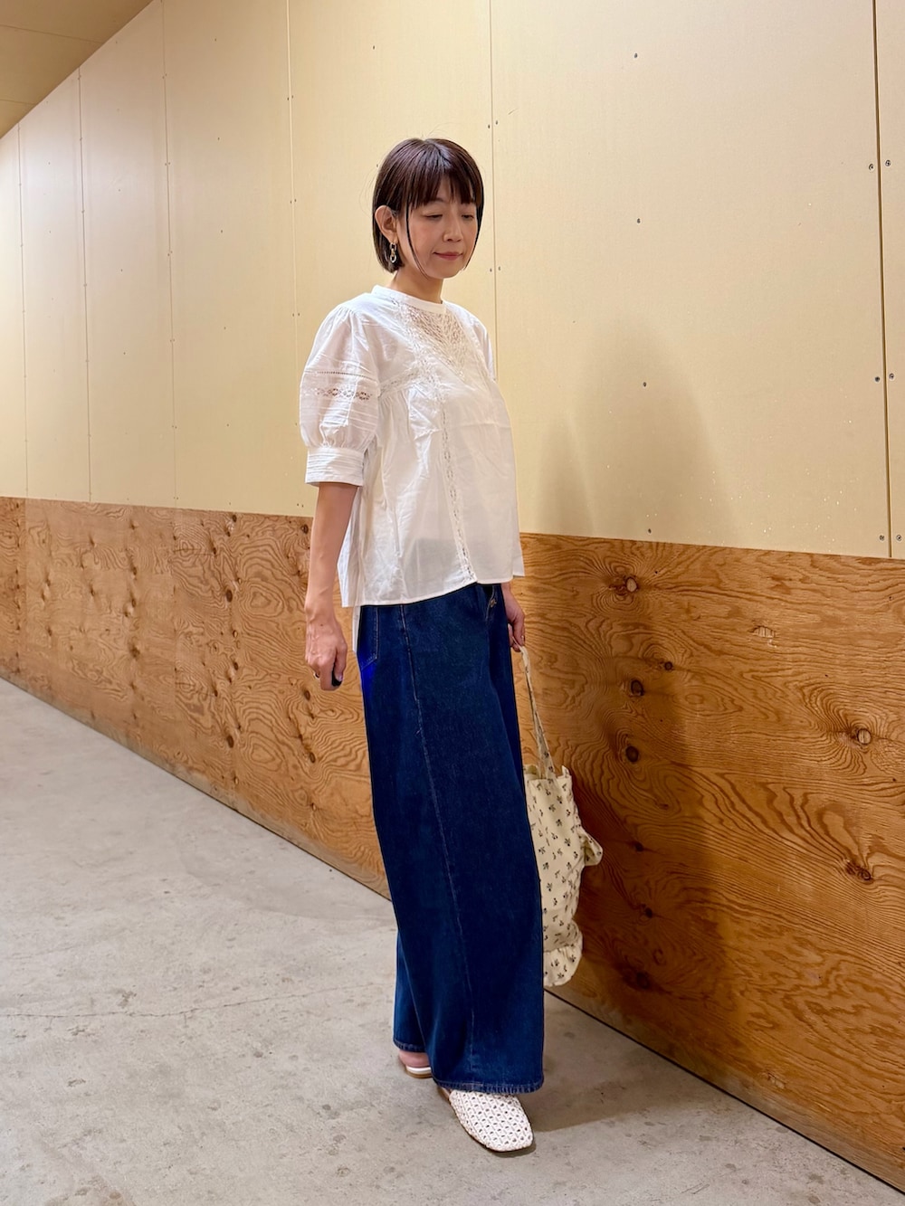 ブルー系のデニムパンツ、ホワイト系のトートバッグ、ホワイト系のサンダルを着用したレディースの夏コーディネートの8枚目の写真