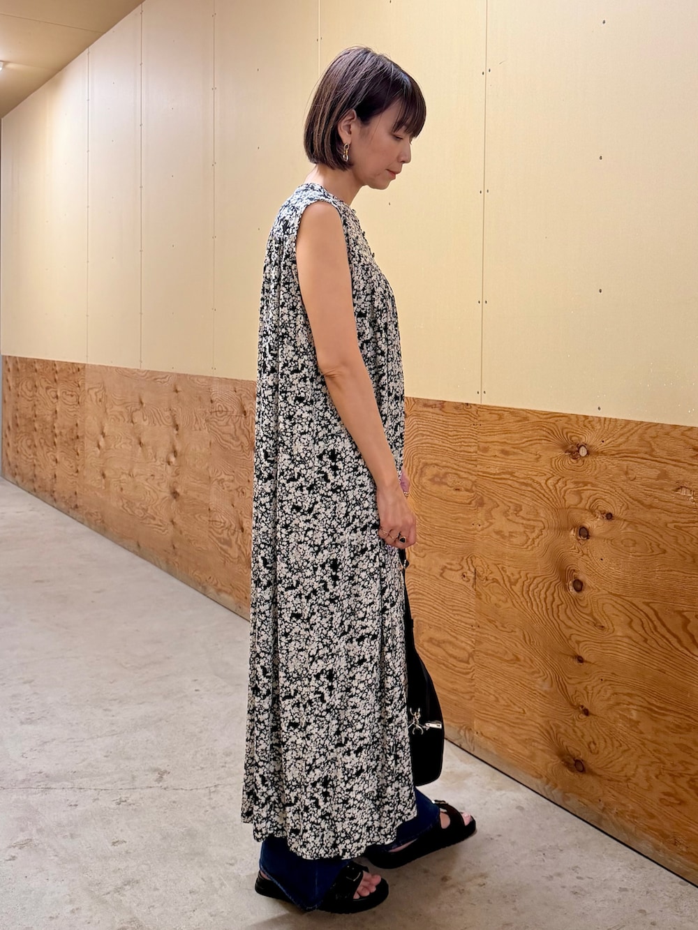 ブラック系のワンピース、ブルー系のデニムパンツ、ブラック系のサンダルを着用したレディースの夏コーディネートの6枚目の写真