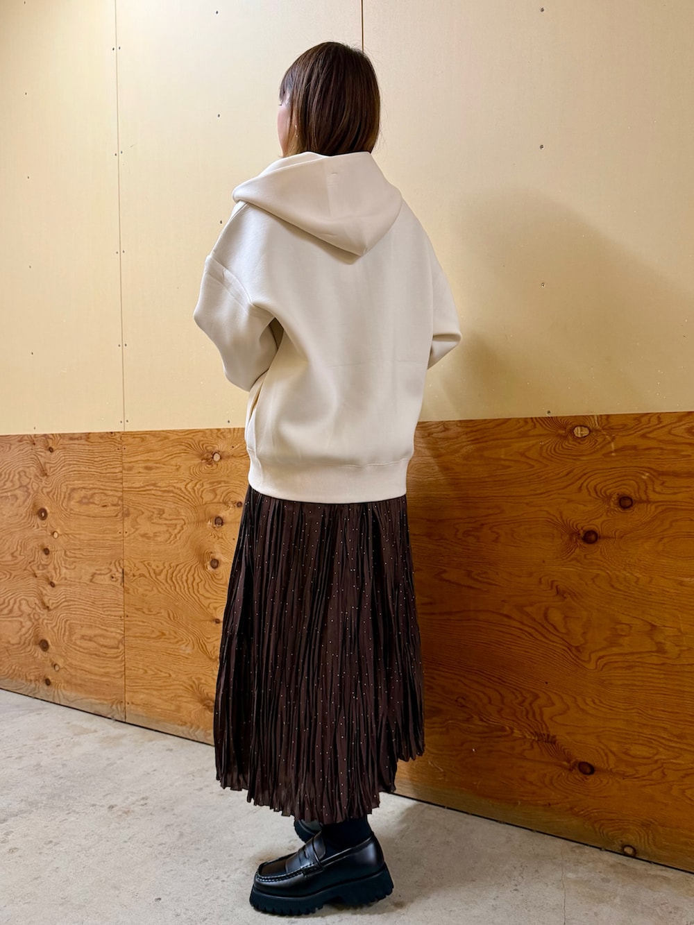 ホワイト系のパーカー、ブルー系のニット/セーター、ブラウン系のスカートを着用したレディースの春コーディネートの3枚目の写真