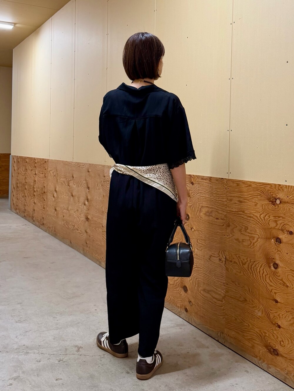 ブラック系のその他パンツ、ブラック系のハンドバッグ、ブラウン系のネックレスを着用したレディースの秋コーディネートの4枚目の写真