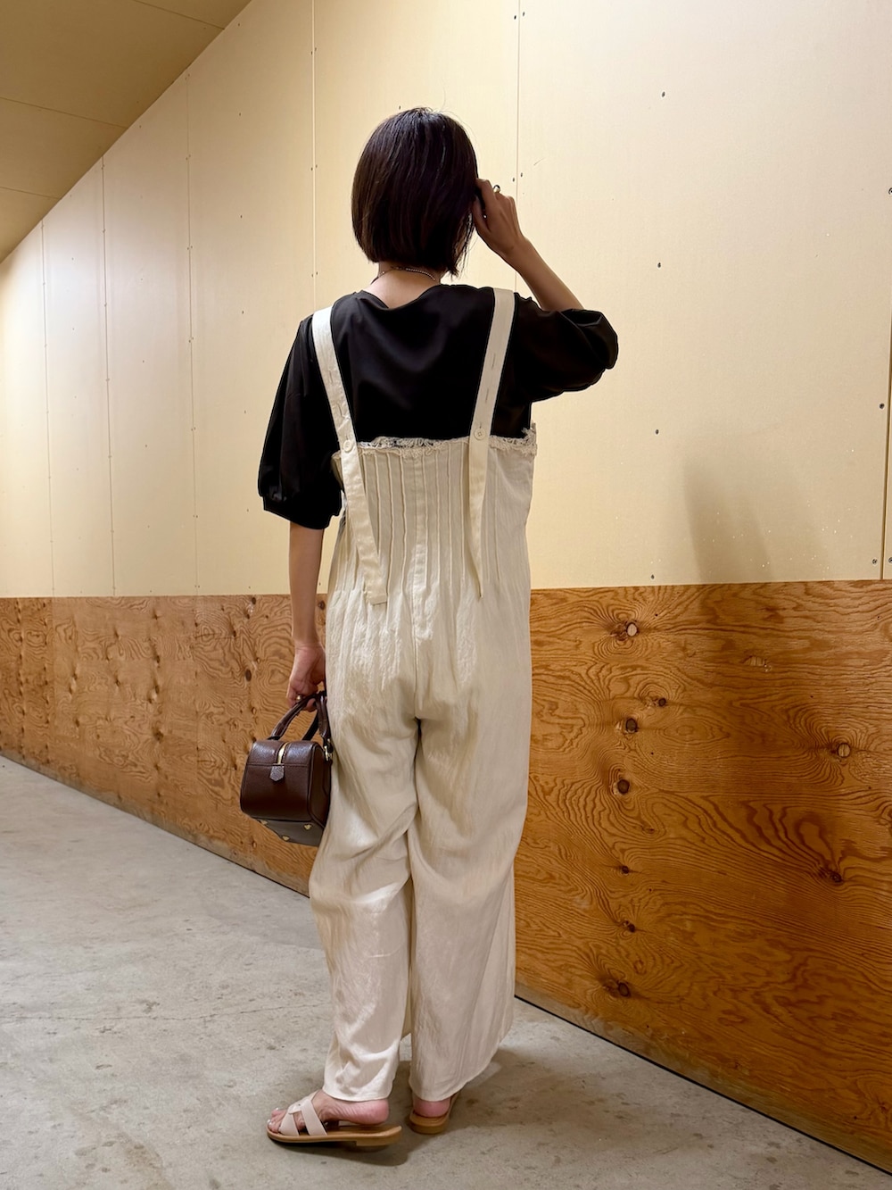 ブラウン系のTシャツ/カットソー、ホワイト系のその他パンツ、ブラウン系のハンドバッグを着用したレディースの夏コーディネートの3枚目の写真