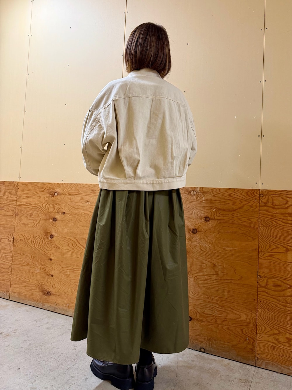 ホワイト系のブルゾン、ブラック系のシャツ/ブラウス、グリーン系のスカートを着用したレディースの冬コーディネートの4枚目の写真