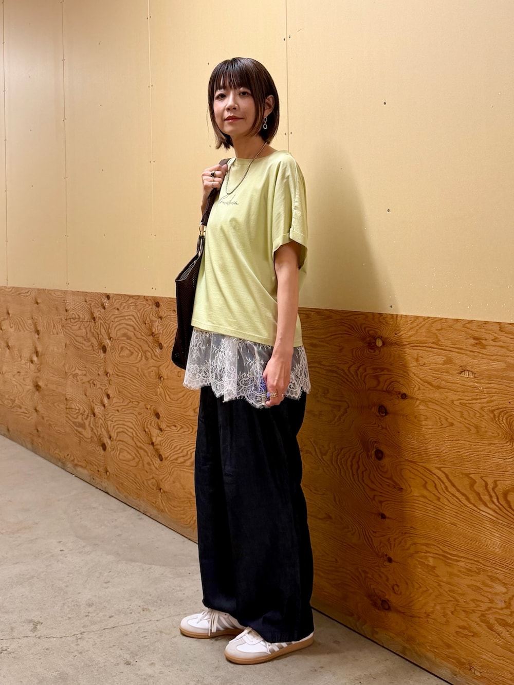 ブラウン系のTシャツ/カットソー、ベージュ系のキャミソール、ブルー系のデニムパンツを着用したレディースの春コーディネートの3枚目の写真