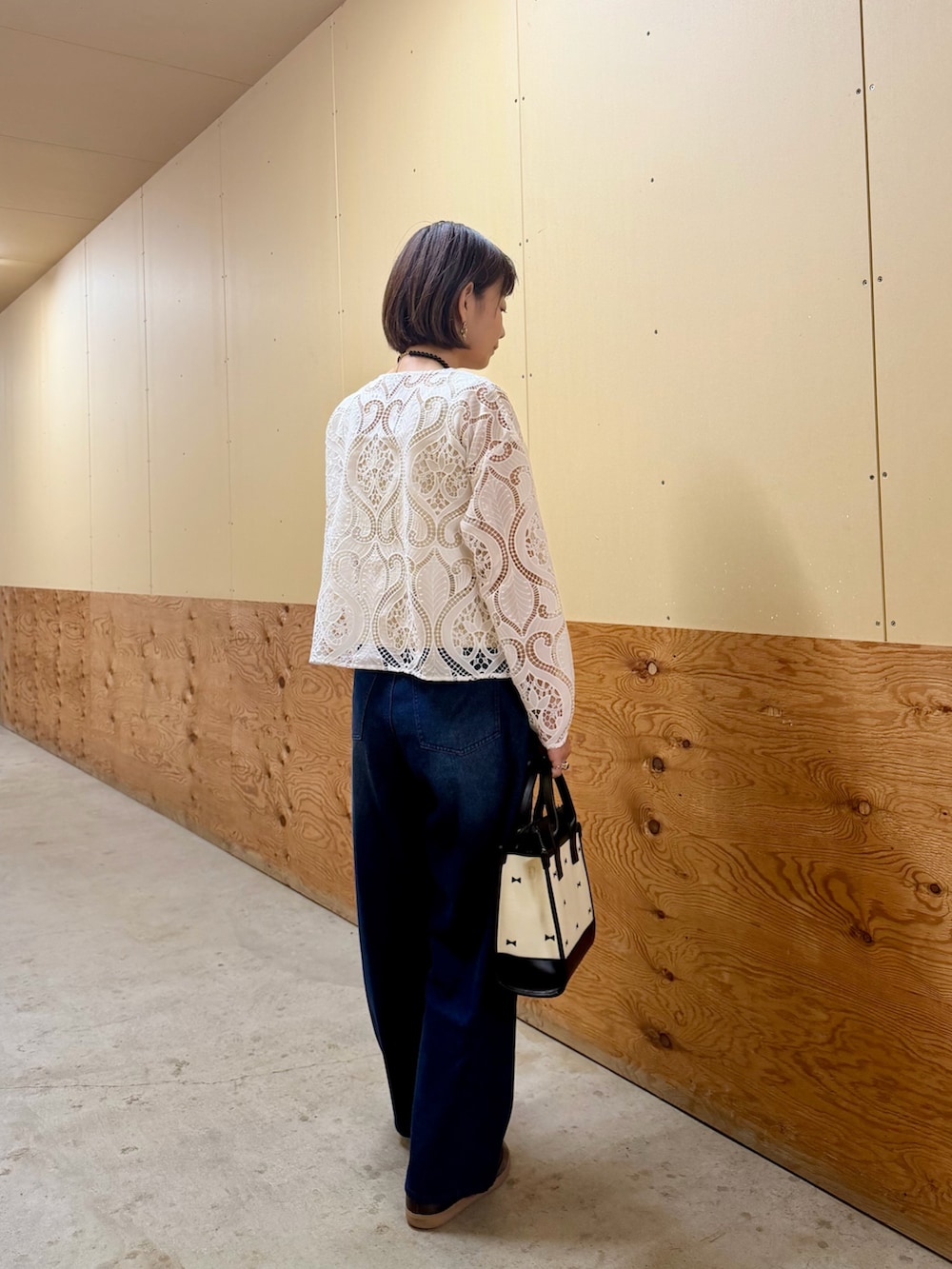 ホワイト系のシャツ/ブラウス、ブルー系のその他パンツ、ブラック系のハンドバッグを着用したレディースの秋コーディネートの3枚目の写真