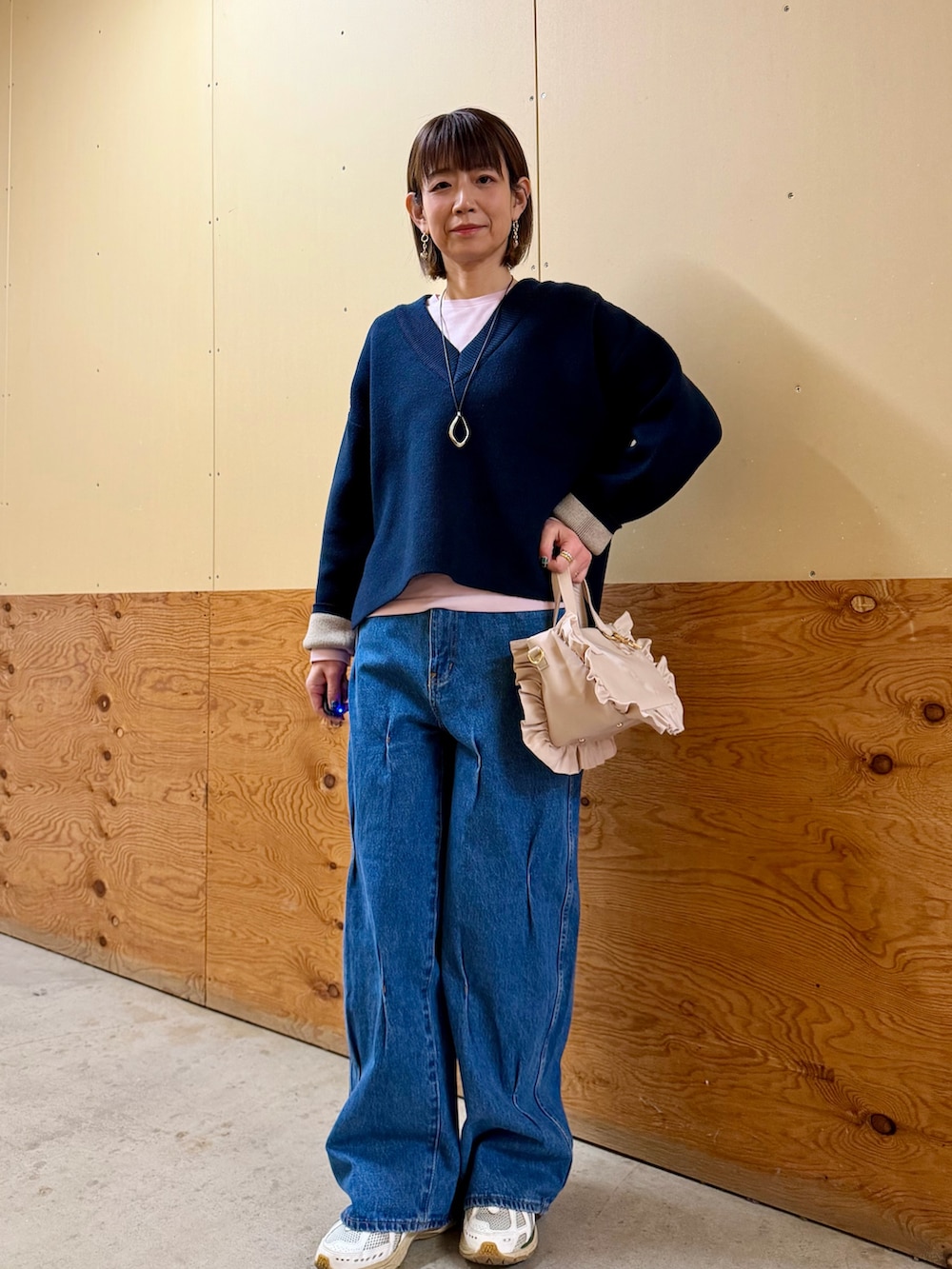 ブルー系のニット/セーター、ピンク系のTシャツ/カットソー、ブルー系のデニムパンツを着用したレディースの冬コーディネートの2枚目の写真