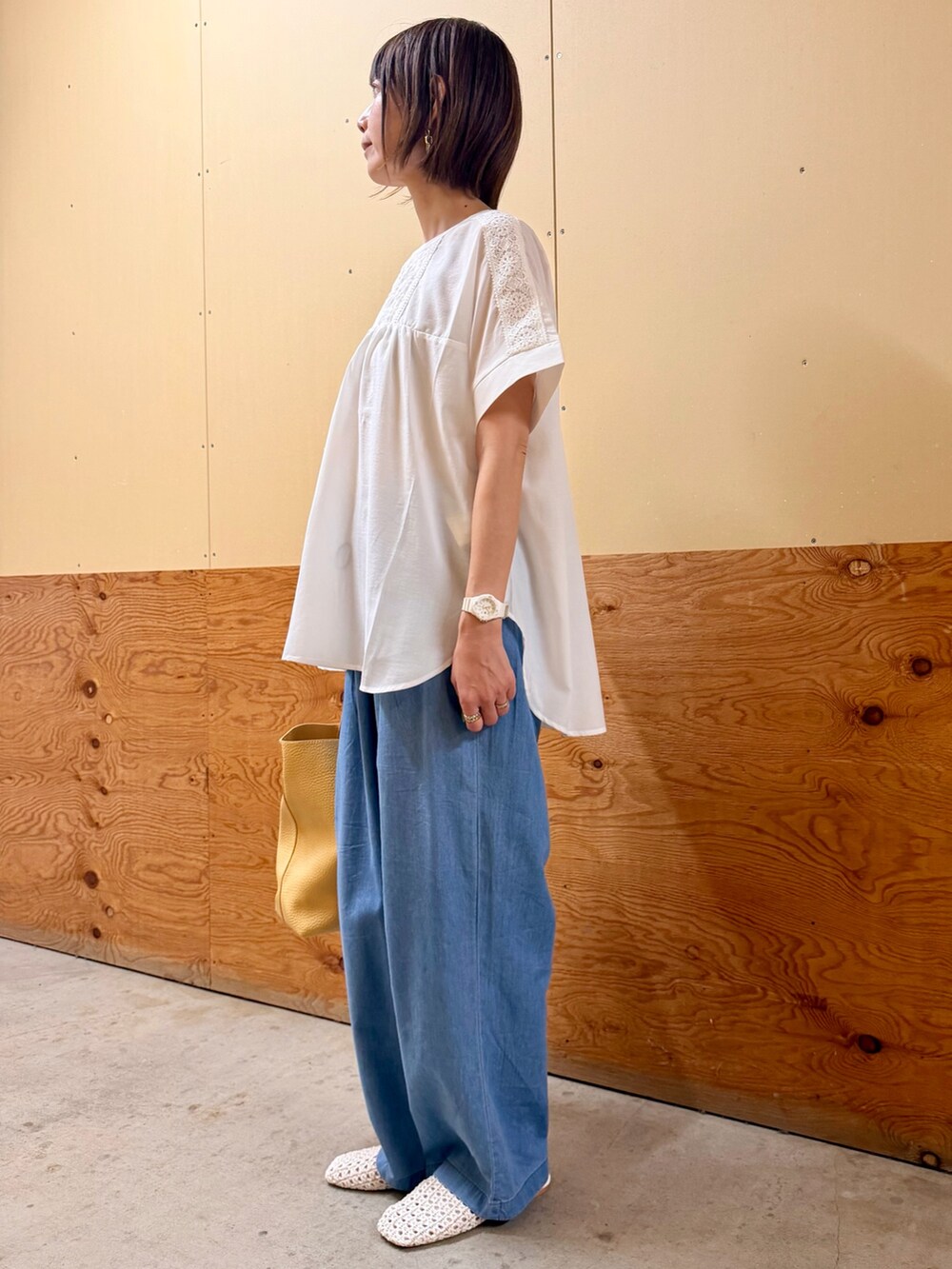 ホワイト系のシャツ/ブラウス、ブルー系のデニムパンツ、ベージュ系のトートバッグを着用したレディースの春コーディネートの2枚目の写真