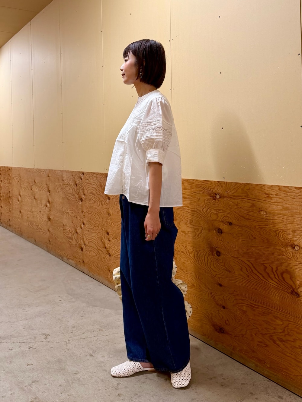 ブルー系のデニムパンツ、ホワイト系のトートバッグ、ホワイト系のサンダルを着用したレディースの夏コーディネートの3枚目の写真
