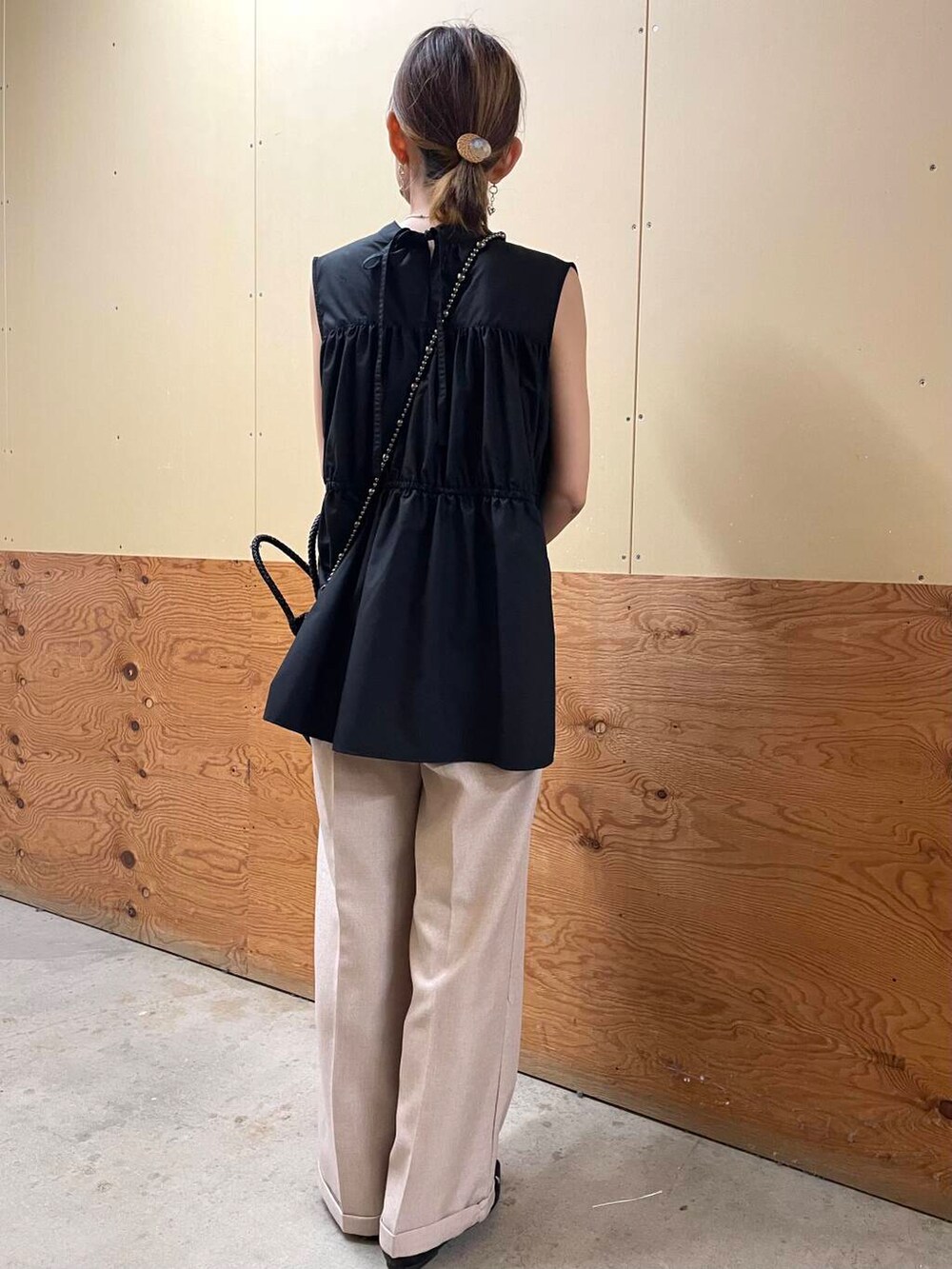 ブラック系のパンプス、ブラック系のショルダーバッグ、ベージュ系のその他パンツを着用したレディースの夏コーディネートの3枚目の写真