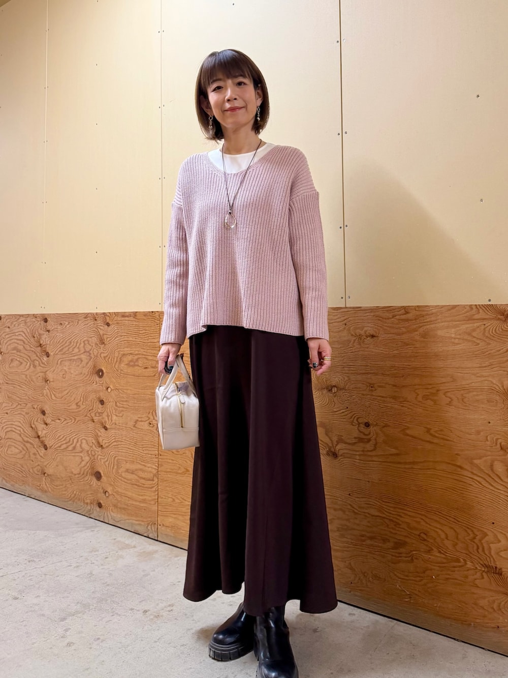 グレー系のボストンバッグ、ピンク系のワンピース、ホワイト系のシャツ/ブラウスを着用したレディースの春コーディネートの2枚目の写真