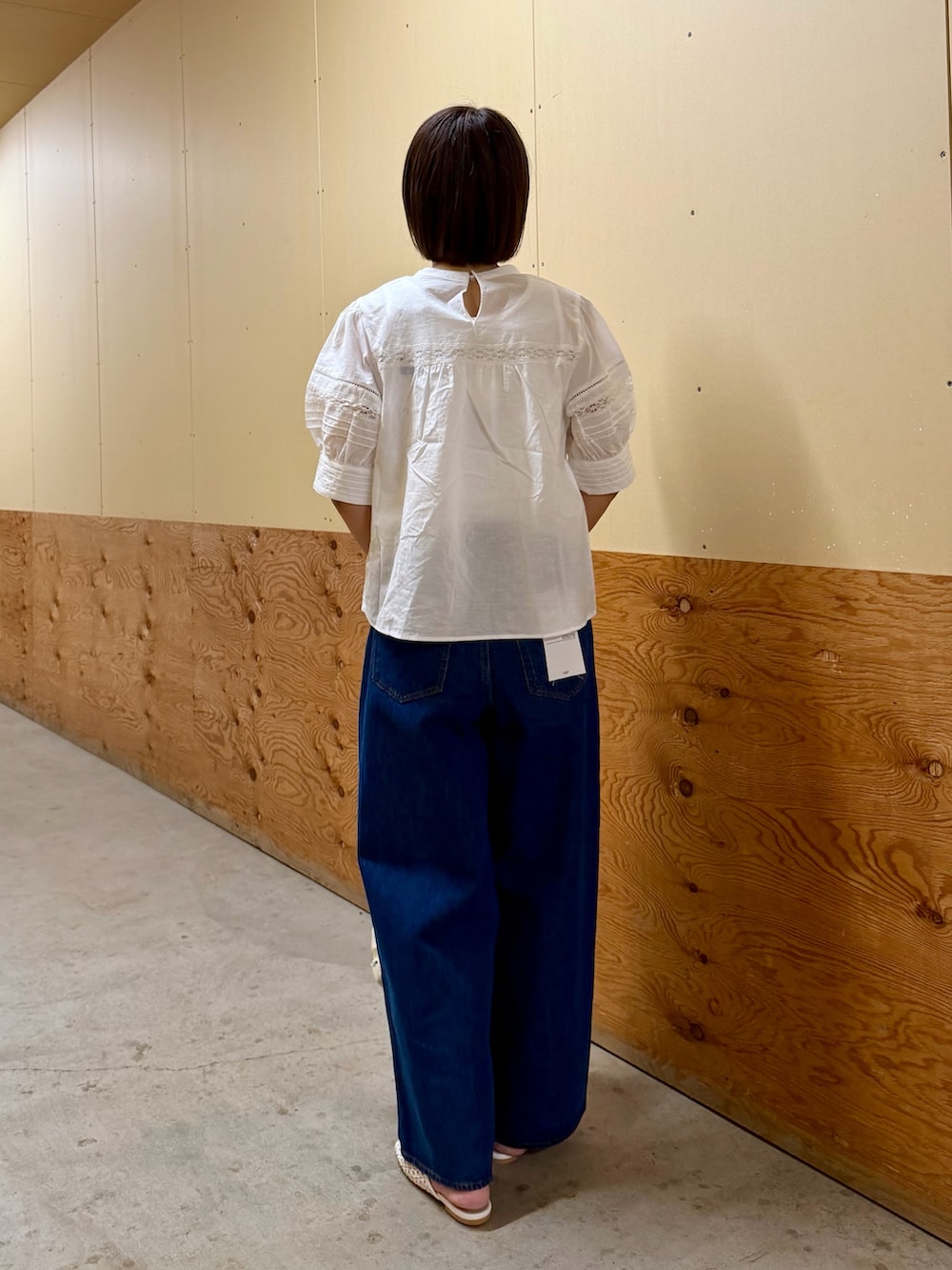 ブルー系のデニムパンツ、ホワイト系のトートバッグ、ホワイト系のサンダルを着用したレディースの夏コーディネートの5枚目の写真