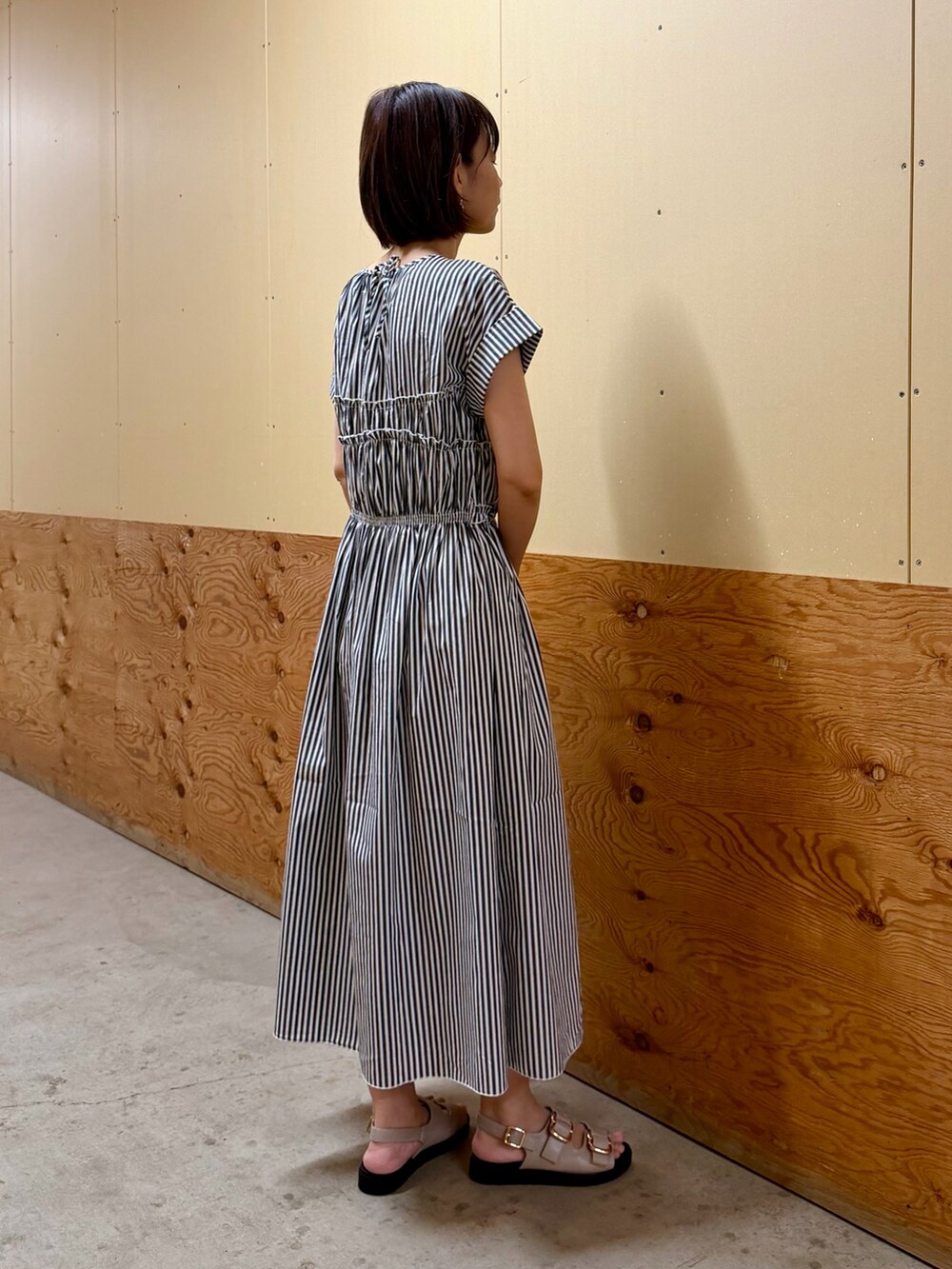 ブラック系のワンピース、ブラウン系のハンドバッグ、グレー系のサンダルを着用したレディースの夏コーディネートの5枚目の写真