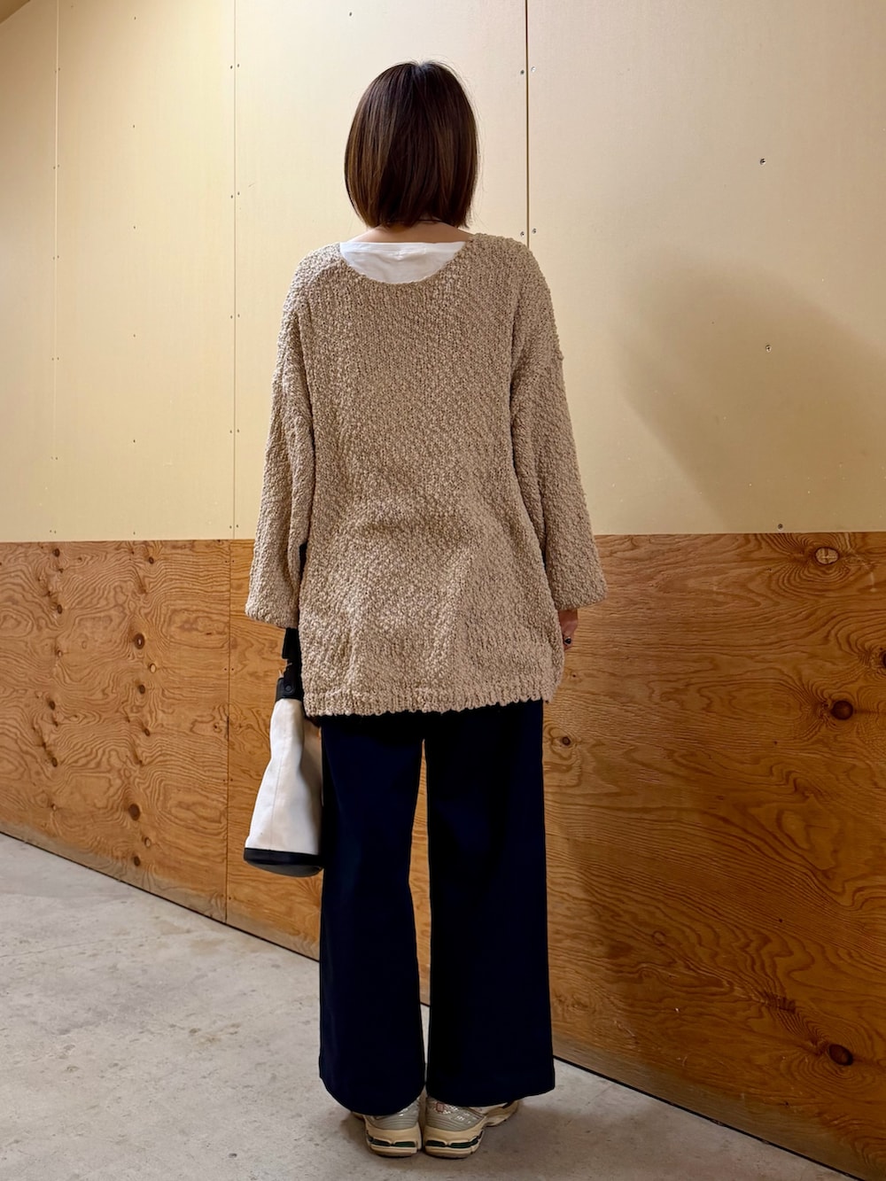 ベージュ系のニット/セーター、ブルー系のその他パンツ、ブラック系のショルダーバッグを着用したレディースの春コーディネートの6枚目の写真