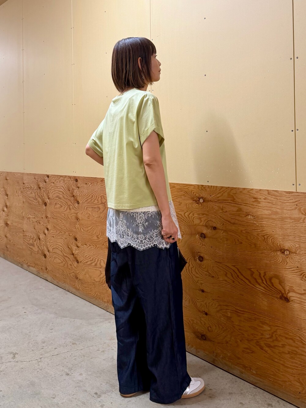 ブラウン系のTシャツ/カットソー、ベージュ系のキャミソール、ブルー系のデニムパンツを着用したレディースの春コーディネートの7枚目の写真