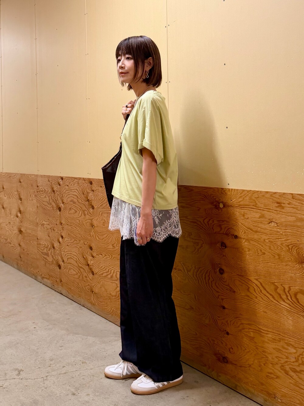 ブラウン系のTシャツ/カットソー、ベージュ系のキャミソール、ブルー系のデニムパンツを着用したレディースの春コーディネートの4枚目の写真