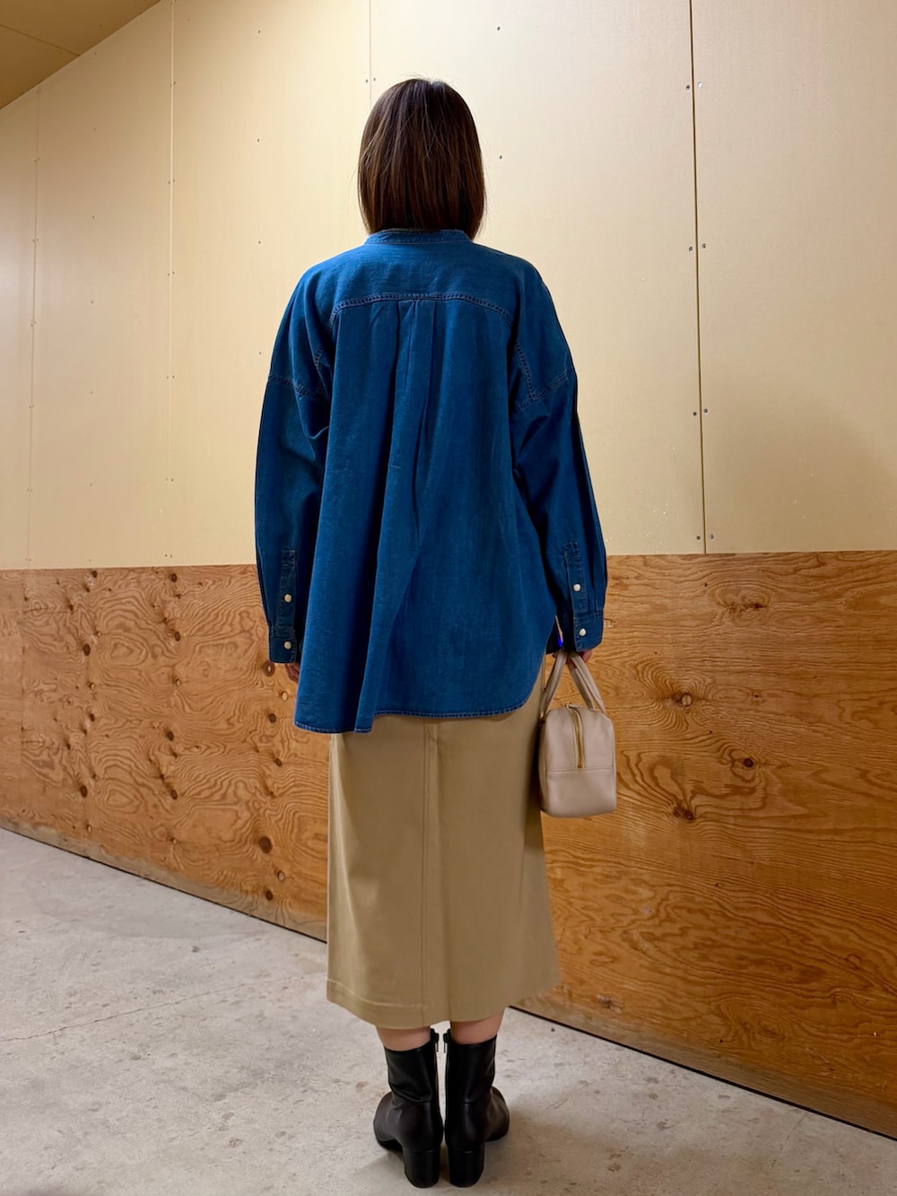 ブルー系のシャツ/ブラウス、グリーン系のニット/セーター、ベージュ系のスカートを着用したレディースの冬コーディネートの4枚目の写真