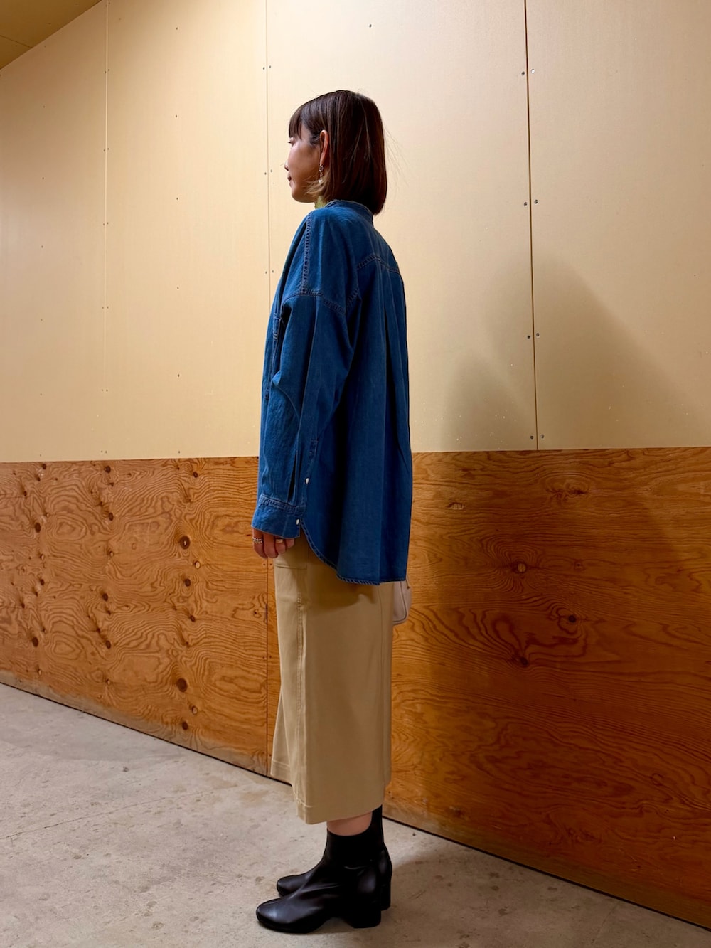 ブルー系のシャツ/ブラウス、グリーン系のニット/セーター、ベージュ系のスカートを着用したレディースの冬コーディネートの3枚目の写真