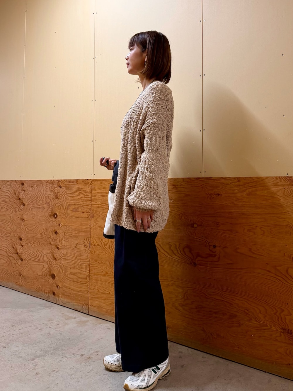 ベージュ系のニット/セーター、ブルー系のその他パンツ、ブラック系のショルダーバッグを着用したレディースの春コーディネートの4枚目の写真