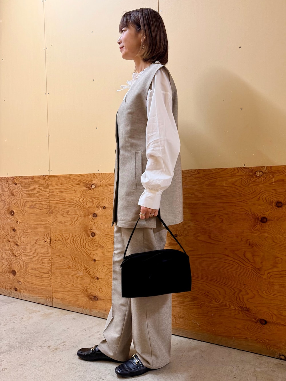 ベージュ系のセットアップ、ホワイト系のシャツ/ブラウス、ブラック系のトートバッグを着用したレディースの冬コーディネートの2枚目の写真
