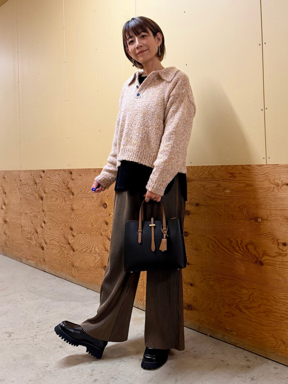 ピンク系のニット/セーター、ブラウン系のその他パンツ、ブラック系のTシャツ/カットソーを着用したレディースの秋コーディネートの3枚目の写真