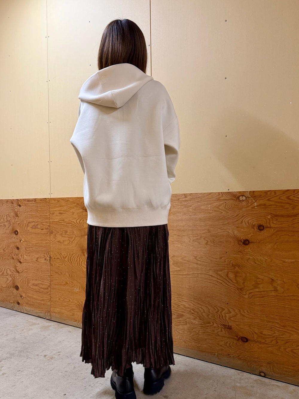 ホワイト系のパーカー、ブルー系のニット/セーター、ブラウン系のスカートを着用したレディースの春コーディネートの4枚目の写真