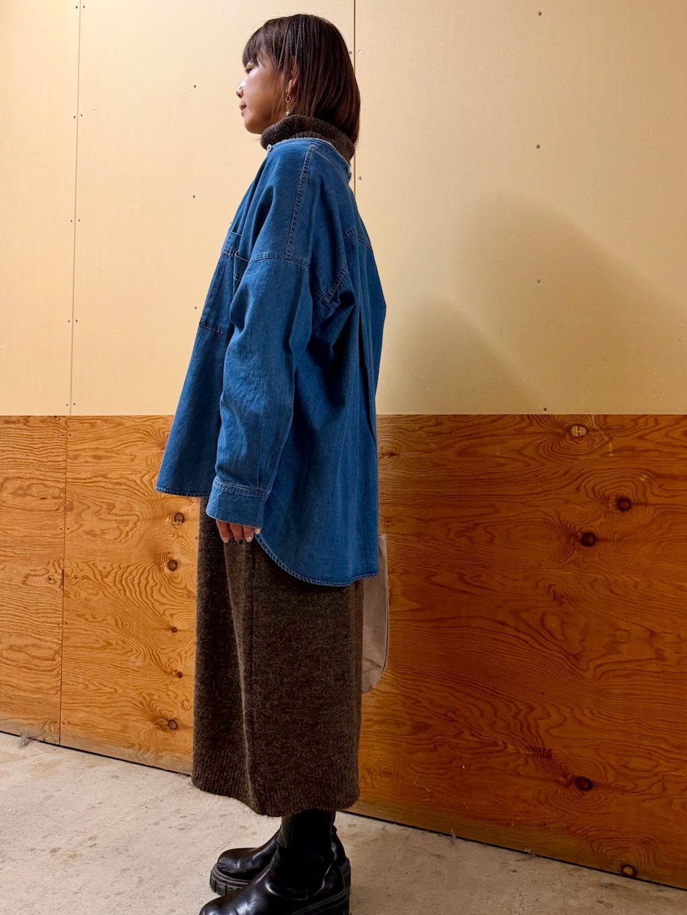 ブラウン系のワンピース、ブルー系のシャツ/ブラウス、グレー系のトートバッグを着用したレディースの冬コーディネートの2枚目の写真