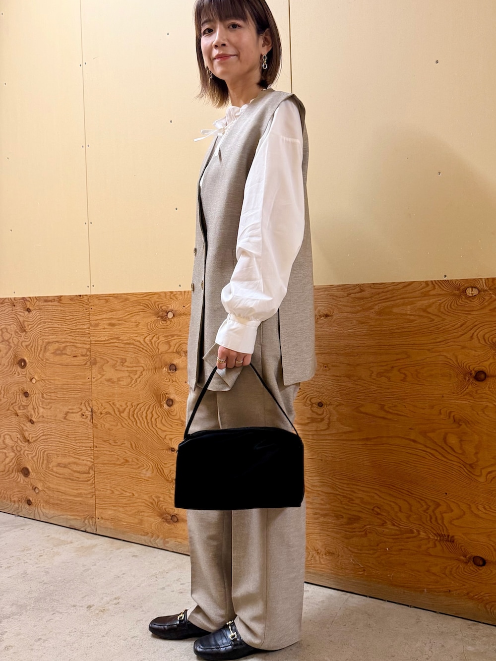 ベージュ系のセットアップ、ホワイト系のシャツ/ブラウス、ブラック系のトートバッグを着用したレディースの冬コーディネートの6枚目の写真