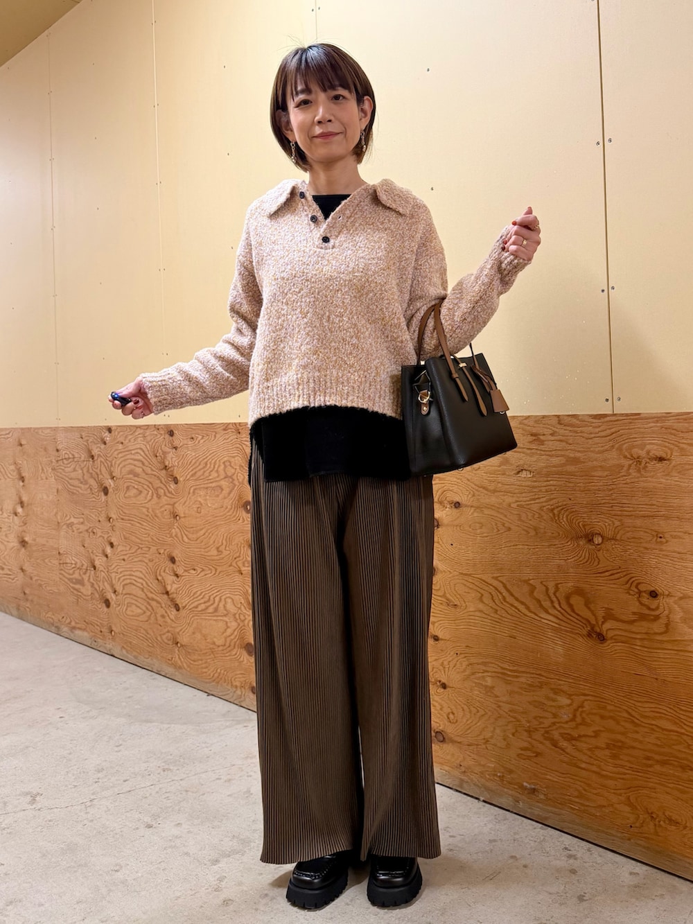 ピンク系のニット/セーター、ブラウン系のその他パンツ、ブラック系のTシャツ/カットソーを着用したレディースの秋コーディネートの2枚目の写真