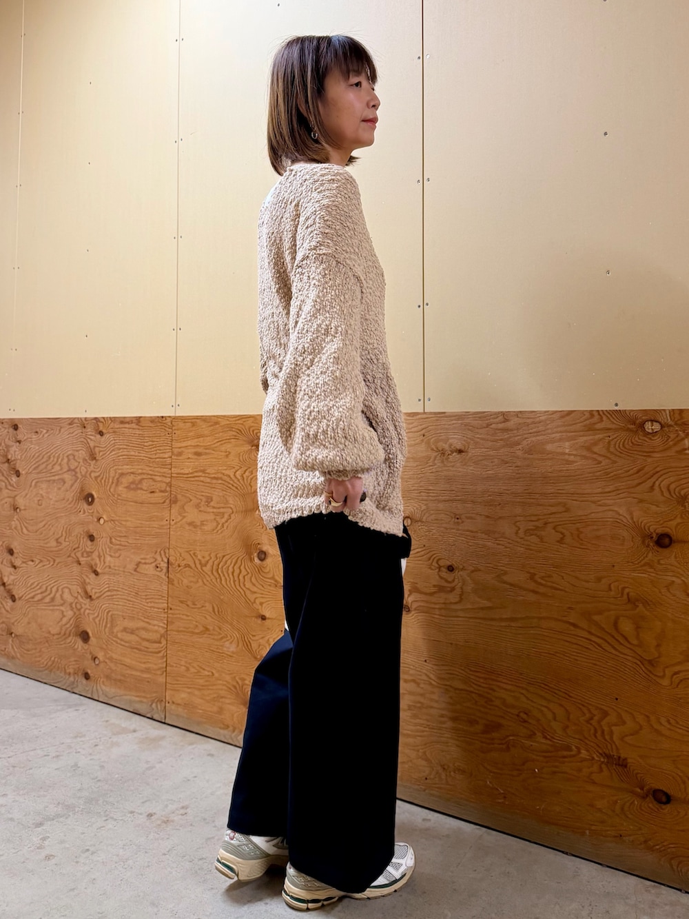 ベージュ系のニット/セーター、ブルー系のその他パンツ、ブラック系のショルダーバッグを着用したレディースの春コーディネートの5枚目の写真