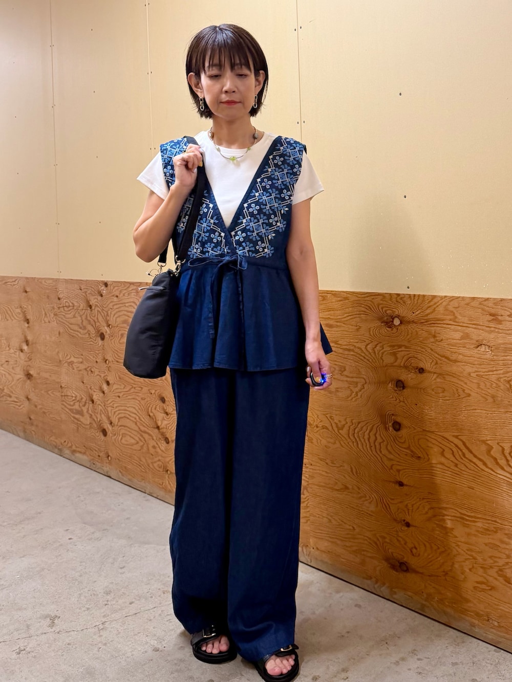 ブルー系のサロペット/オーバーオール、ホワイト系のTシャツ/カットソー、ブラック系のサンダルを着用したレディースの夏コーディネートの7枚目の写真