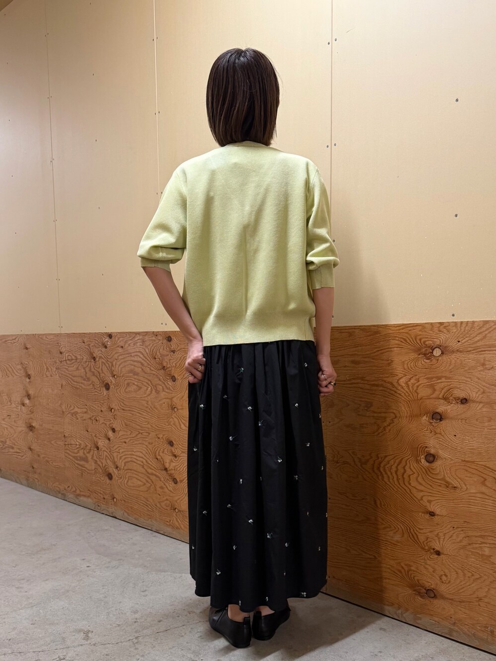 イエロー系のカーディガン/ボレロ、ブラック系のスカート、ホワイト系のTシャツ/カットソーを着用したレディースの春コーディネートの3枚目の写真