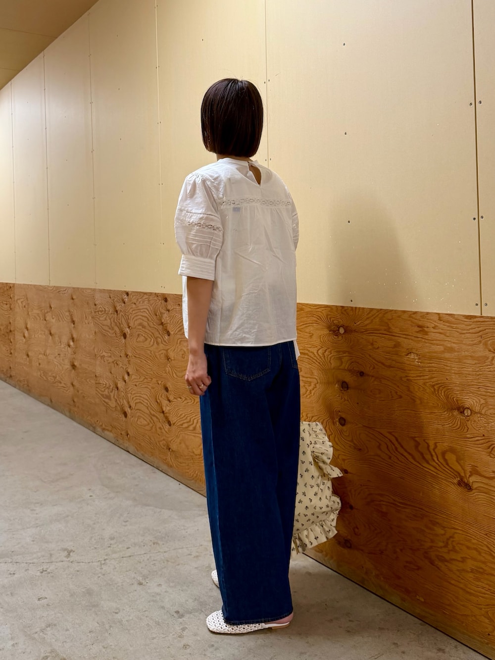 ブルー系のデニムパンツ、ホワイト系のトートバッグ、ホワイト系のサンダルを着用したレディースの夏コーディネートの4枚目の写真