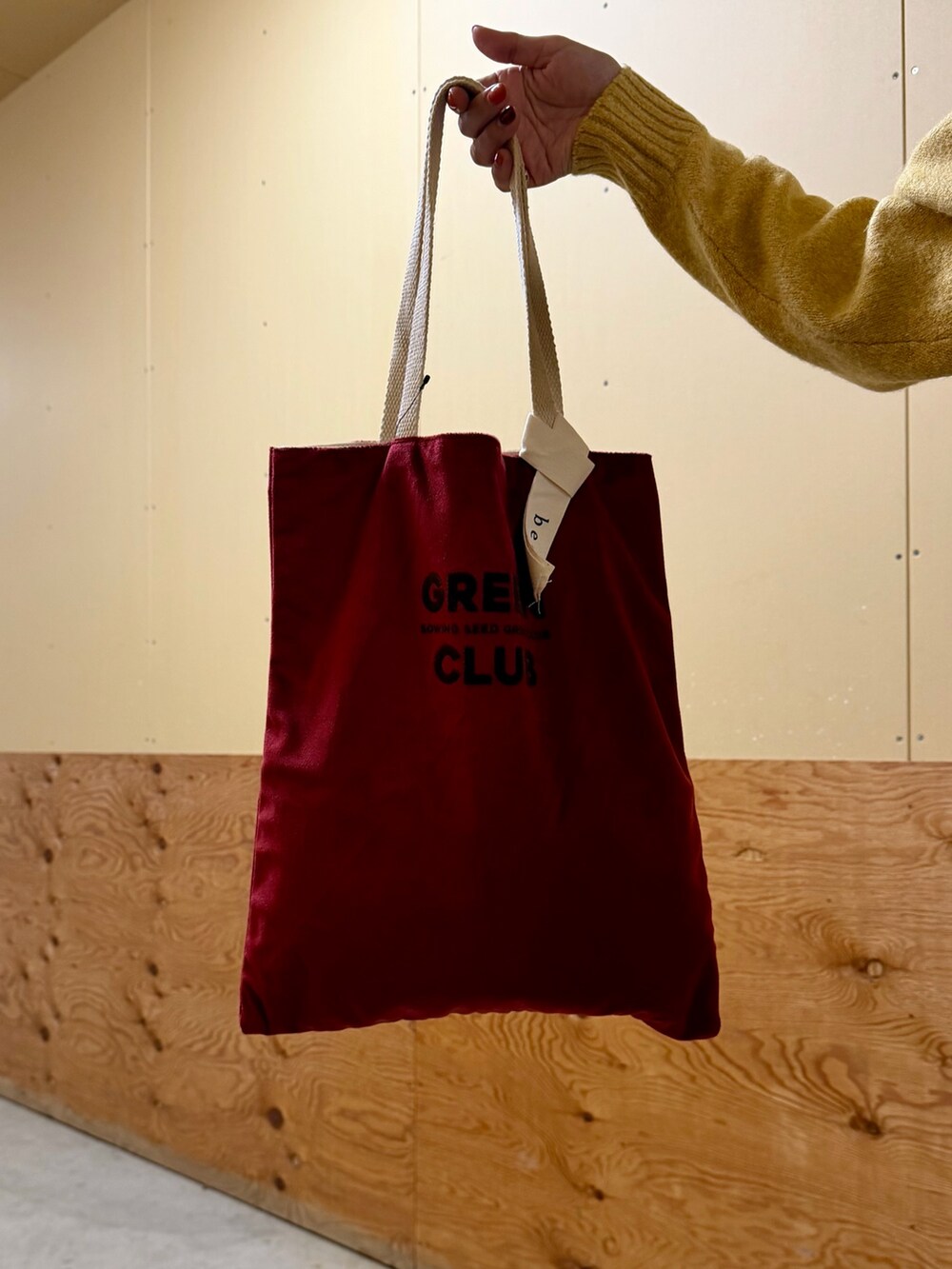 ブラック系のワンピース、イエロー系のニット/セーター、レッド系のトートバッグを着用したレディースの秋コーディネートの4枚目の写真