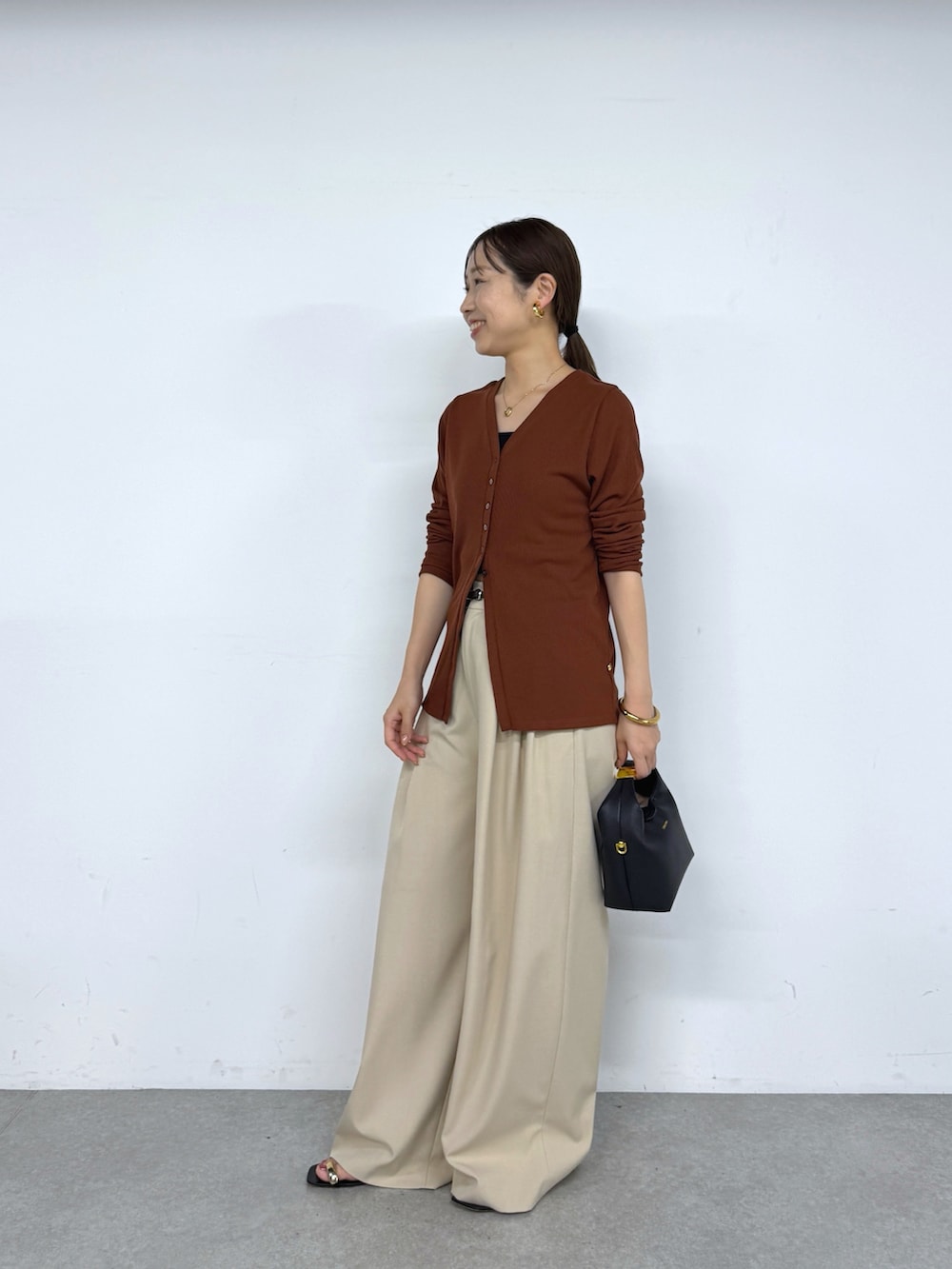 ブラウン系のカーディガン/ボレロ、ベージュ系のその他パンツ、ブラック系のベルトを着用したレディースの夏コーディネートの2枚目の写真