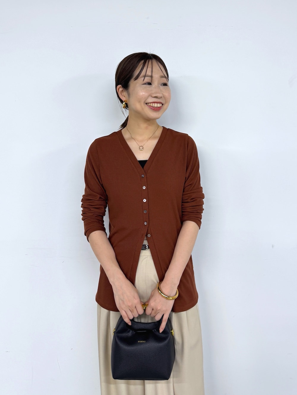 ブラウン系のカーディガン/ボレロ、ベージュ系のその他パンツ、ブラック系のベルトを着用したレディースの夏コーディネートの6枚目の写真