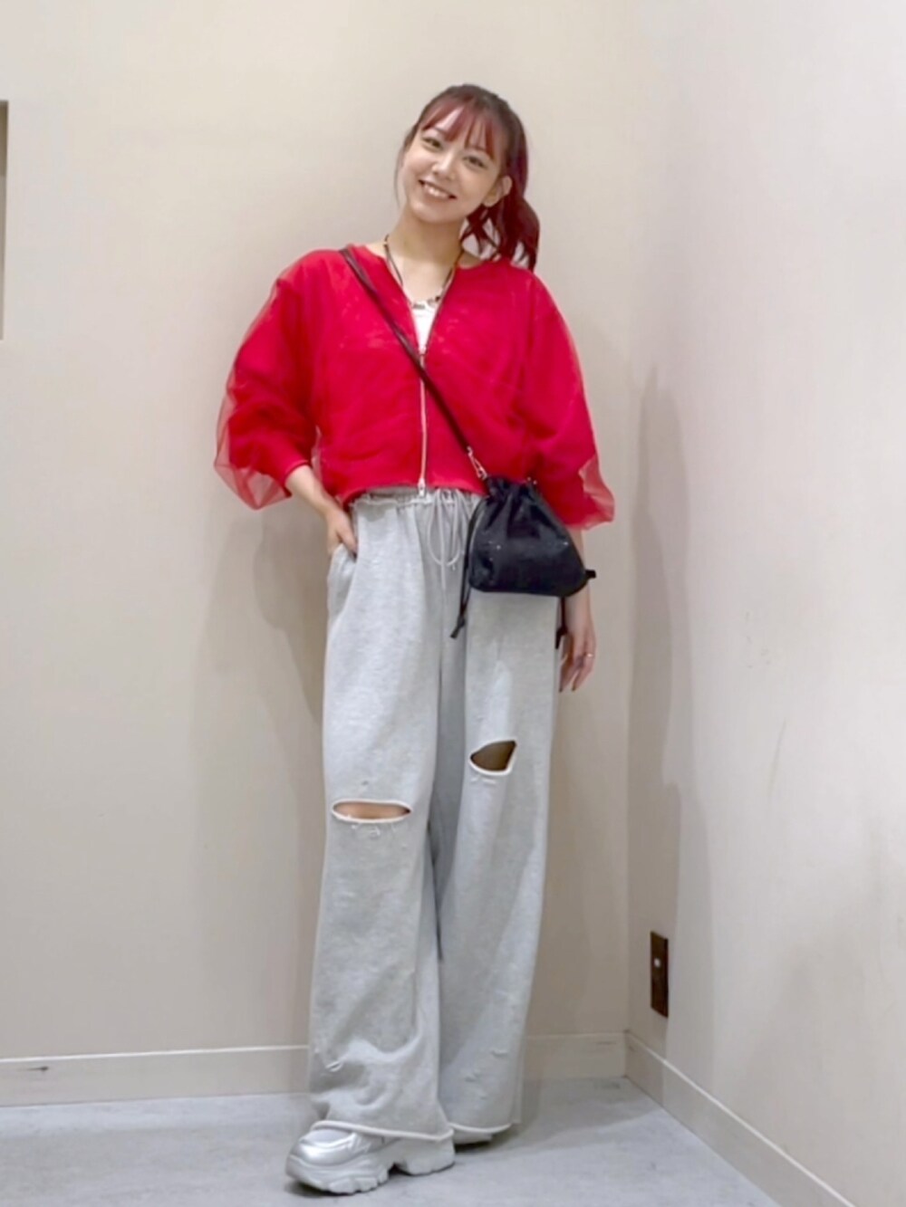 レッド系のカーディガン/ボレロ、グレー系のスウェットパンツを着用したレディースの秋コーディネートの2枚目の写真