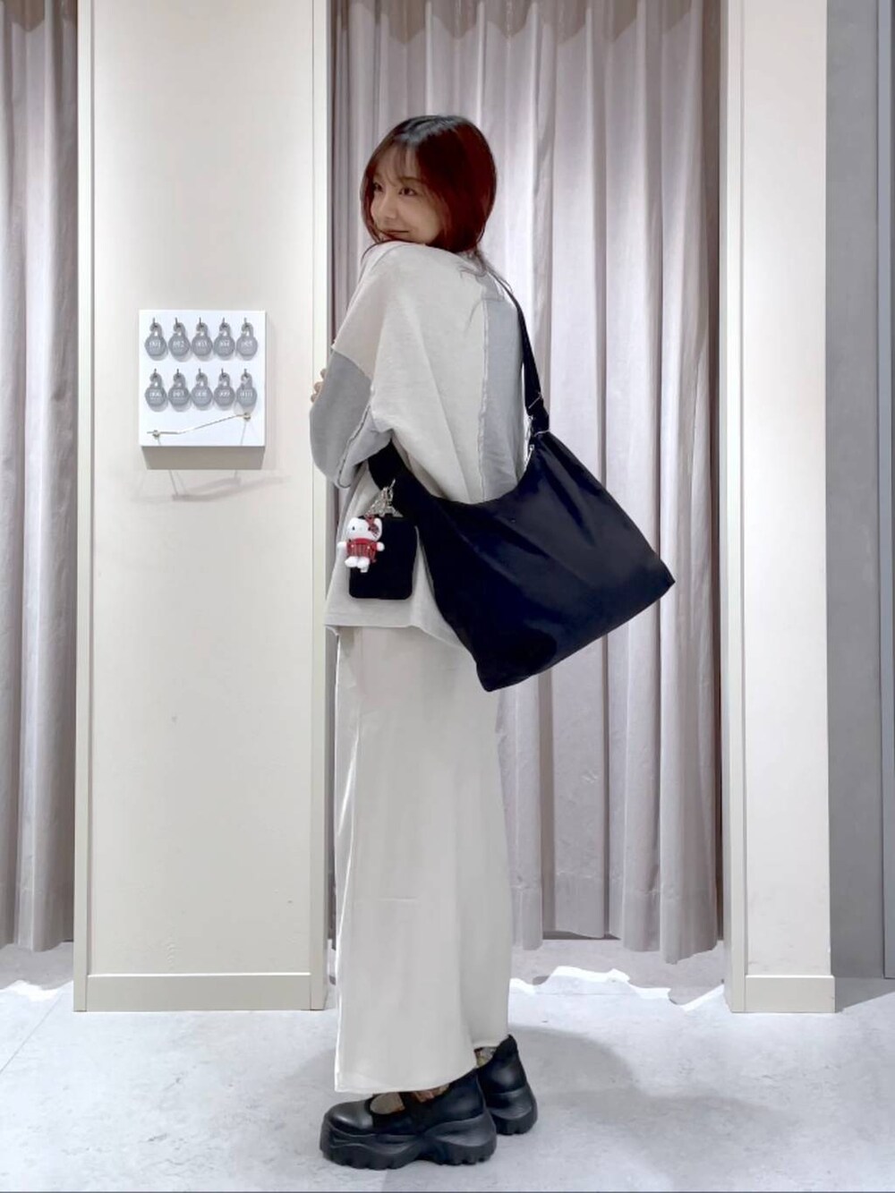 ブラック系のブーツ、ホワイト系のスカート、グレー系のスウェットを着用したレディースの春コーディネートの2枚目の写真