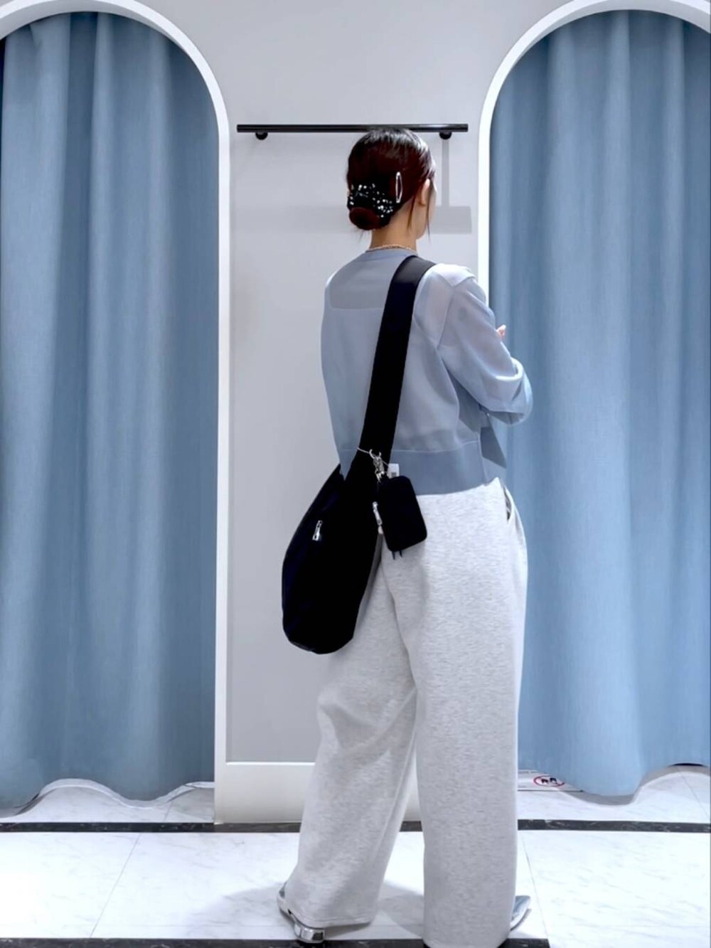 ブラック系のショルダーバッグ、ブラック系のパンプス、グレー系のスウェットパンツを着用したレディースの春コーディネートの3枚目の写真