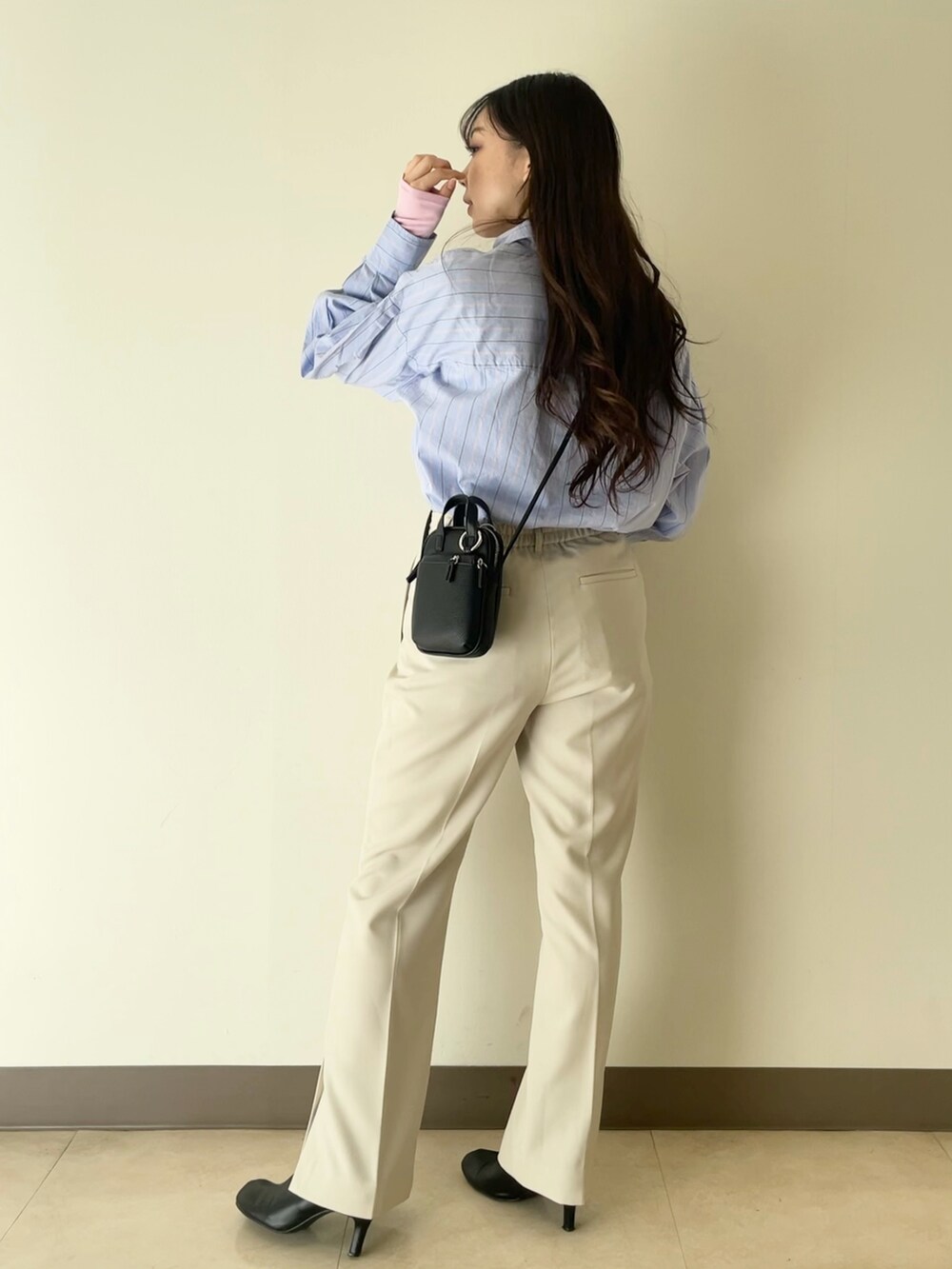 ホワイト系のテーラードジャケット、ホワイト系のその他パンツ、ブラック系のショルダーバッグを着用したレディースの冬コーディネートの5枚目の写真