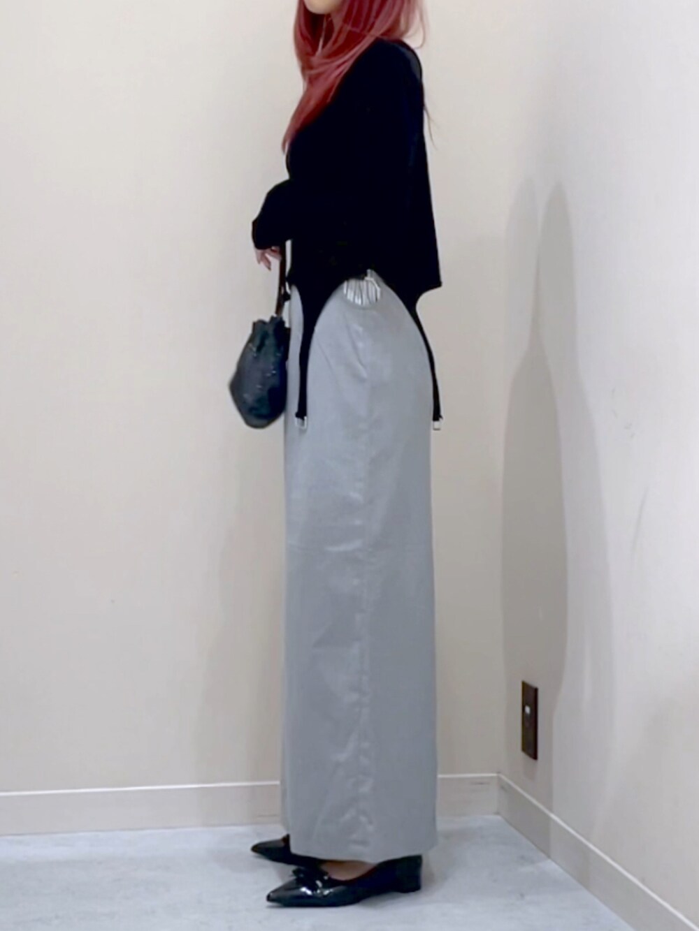ブラック系のパンプス、グレー系のスカート、ブラック系のTシャツ/カットソーを着用したレディースの秋コーディネートの2枚目の写真