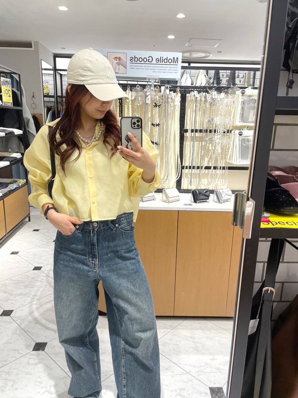 ブルー系のデニムパンツ、イエロー系のシャツ/ブラウス、シルバー系のスニーカーを着用したレディースの春コーディネートの4枚目の写真