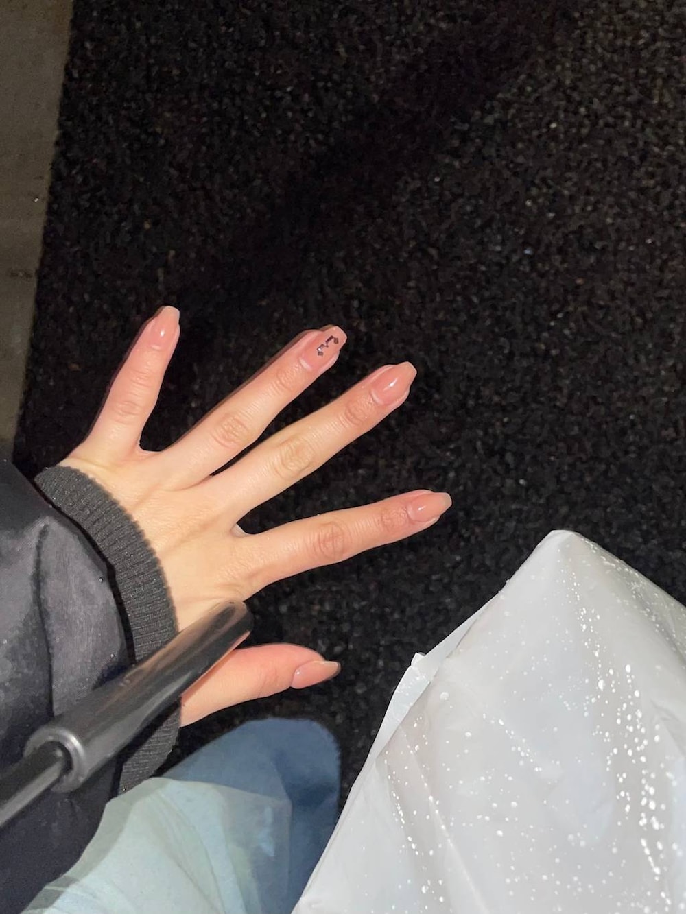 ホワイト系のスカート、グレー系のパーカーを着用したレディースの春コーディネートの3枚目の写真