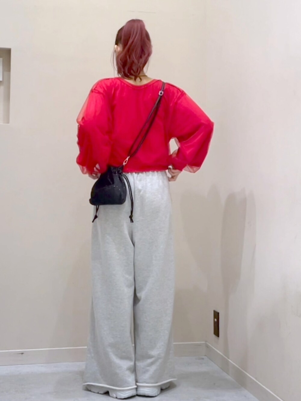 レッド系のカーディガン/ボレロ、グレー系のスウェットパンツを着用したレディースの秋コーディネートの4枚目の写真