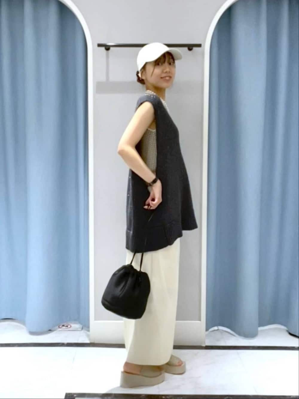 ホワイト系のスカート、ホワイト系のサンダル、グレー系のニット/セーターを着用したレディースの春コーディネートの2枚目の写真