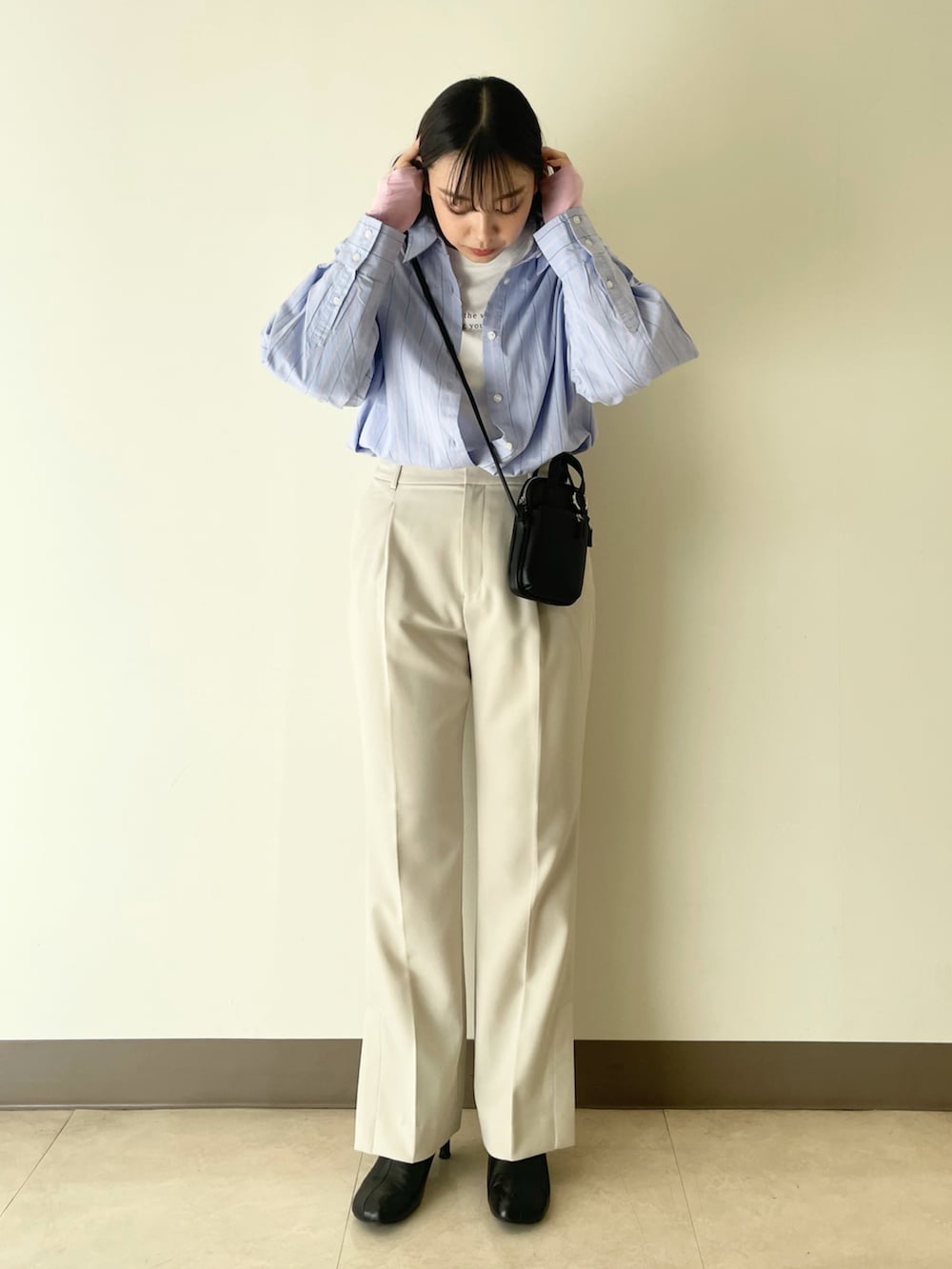 ホワイト系のテーラードジャケット、ホワイト系のその他パンツ、ブラック系のショルダーバッグを着用したレディースの冬コーディネートの4枚目の写真