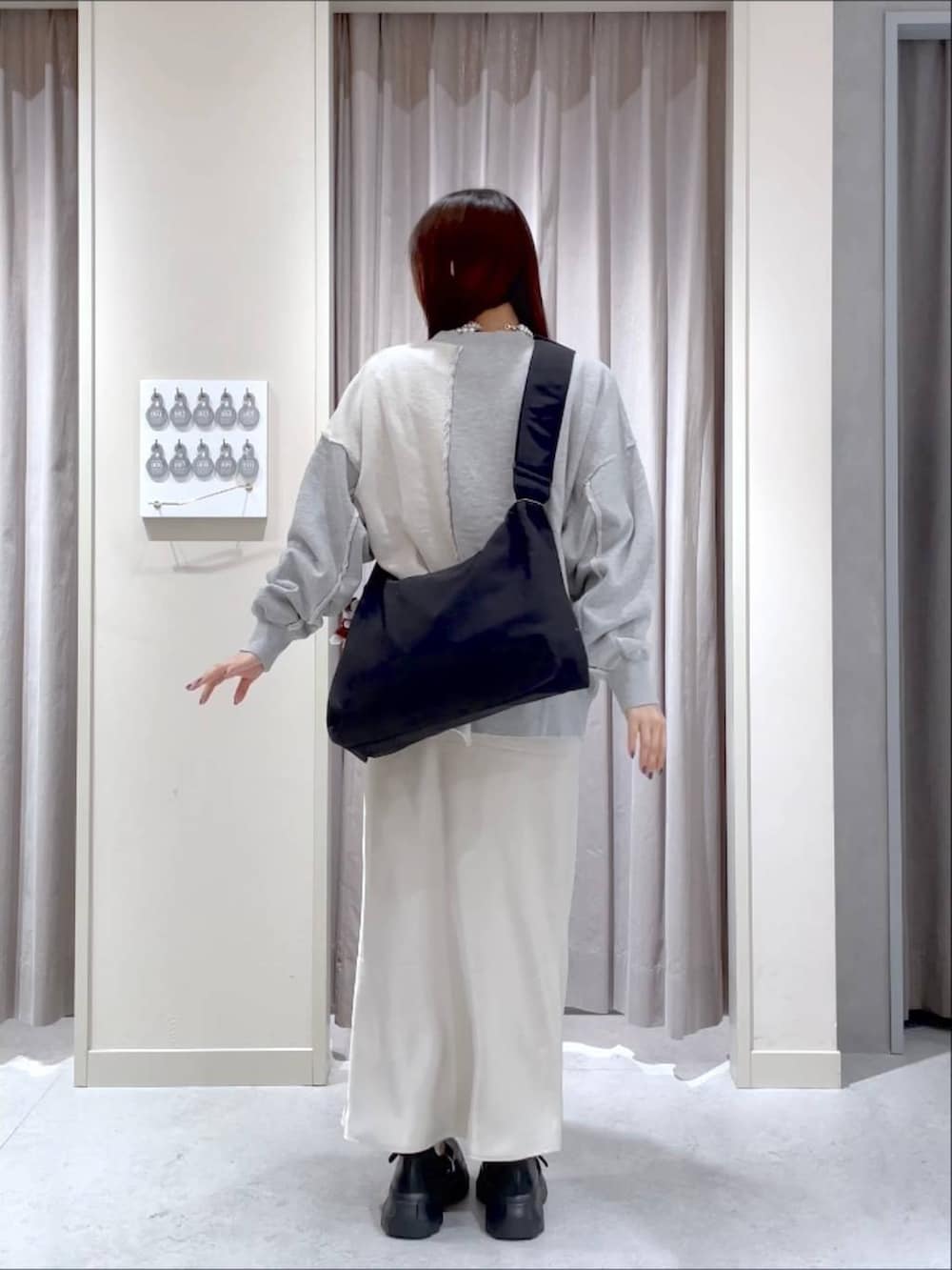 ブラック系のブーツ、ホワイト系のスカート、グレー系のスウェットを着用したレディースの春コーディネートの3枚目の写真